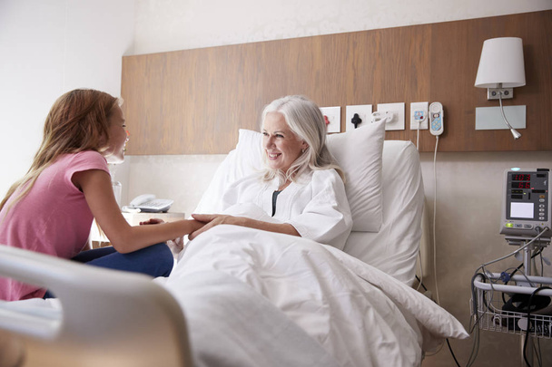 Granddaughter Visiting And Talking With Grandmother In Hospital Bed - Fotografie, Obrázek