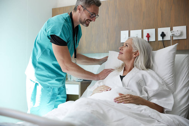 Surgeon Visiting And Talking With Mature Female Patient In Hospital Bed - Foto, Imagem