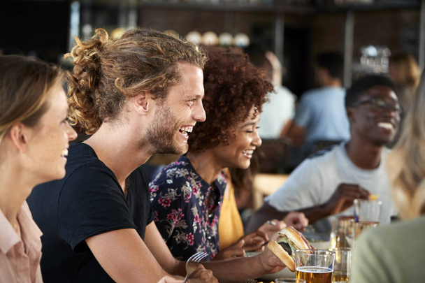 Group Of Young Friends Meeting For Drinks And Food In Restaurant - Photo, Image