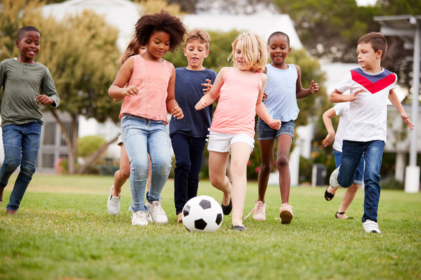 Group Of Children Playing Football With Friends In Park - Foto, Imagen