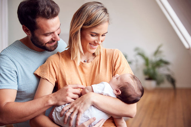 Loving Parents Holding Newborn Baby At Home In Loft Apartment - Zdjęcie, obraz