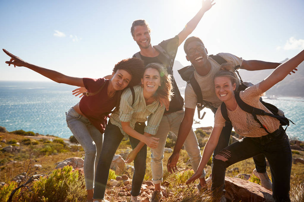 Millennial friends on a hiking trip reaching summit and having fun posing  - Photo, image