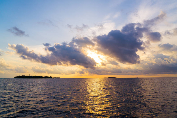 cielo al tramonto con l'isola delle Maldive
 - Foto, immagini