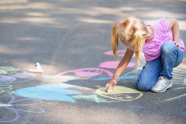 little girl draws with chalk on  pavement - Φωτογραφία, εικόνα