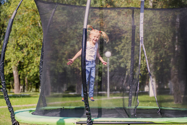 girl jumping on  trampoline in park - Φωτογραφία, εικόνα