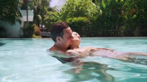hermosa pareja enamorada hombre y mujer en trajes de baño nadar en una piscina en agua azul
. - Metraje, vídeo