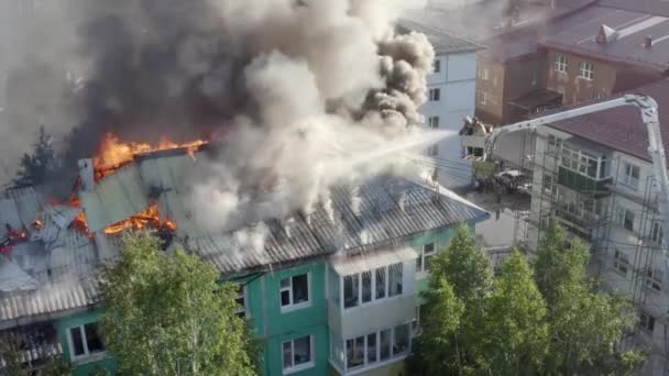 Οι πυροσβέστες σβήνουν μια φωτιά στην οροφή ενός κτιρίου οικιστικής ανόδου. επάνω όψη - Πλάνα, βίντεο