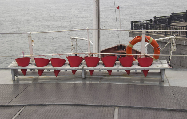 cubos de fuego y boya salvavidas en la cubierta del buque
 - Foto, Imagen