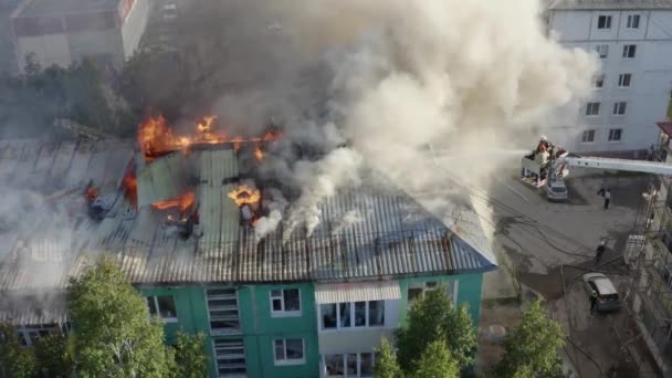 Strażacy gaszenia pożaru na dachu budynku mieszkalnych wieżowcu. Widok z góry - Materiał filmowy, wideo
