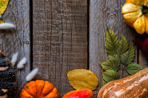 秋の葉とカボチャの秋の背景。コピースペースで熟成木材の秋の収穫。季節のオファーのためのモックアップ。トップビュー. - 写真・画像