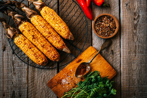 Summer or autumn food background. Ideas for barbecue and grill parties. Grilled corn, cheese on a dark wooden table. Healthy food, organic, bio, homemade food. Top view. - Fotografie, Obrázek