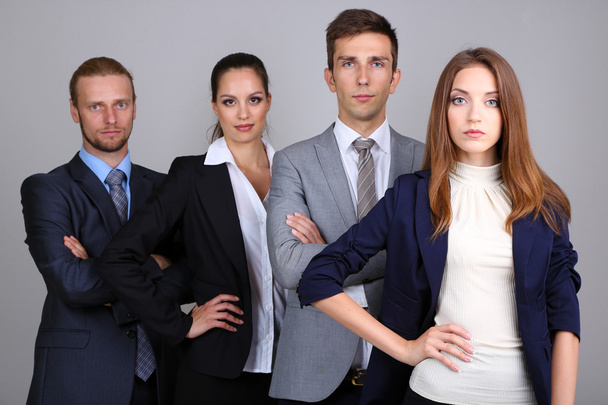 Business team standing in row on grey background - 写真・画像
