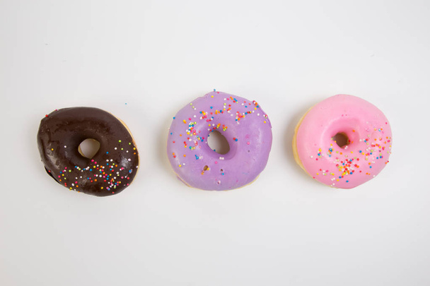 Donut. Sweet icing sugar food. Dessert colorful snack. Glazed sprinkles. Treat from delicious pastry breakfast. Bakery cake. Doughnut with frosting. Baked unhealthy round. - Photo, Image