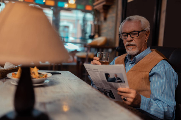 Good-looking man reading newspaper and drinking whisky - Fotoğraf, Görsel