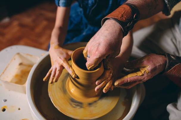 Pottery workshop. Grandpa teaches granddaughter pottery. Clay modeling - Zdjęcie, obraz