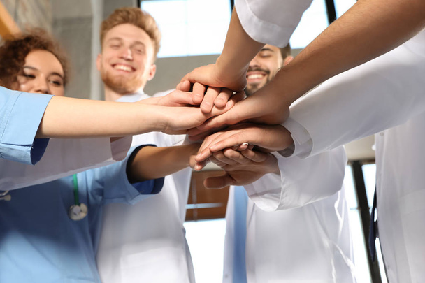 Team van medische medewerkers houden handen samen in hispital, close-up. Unity concept - Foto, afbeelding