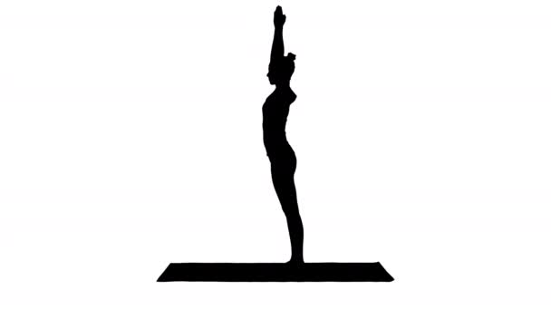 Силуэт Красивая молодая женщина делает упражнения йоги для лодыжек, телят, бедер, бедер и плеч, орлиный поз, Garudasana. - Кадры, видео