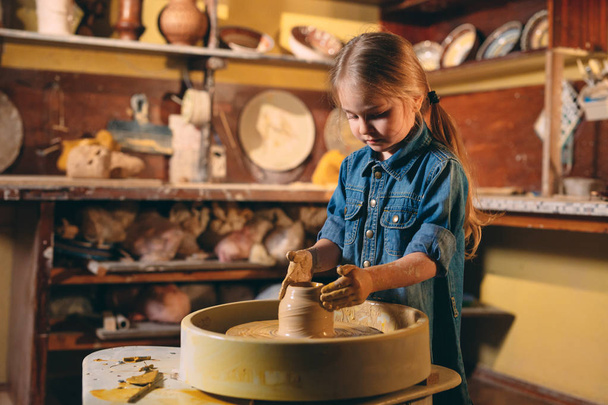 Pottery workshop. A little girl makes a vase of clay. Clay modeling - Fotoğraf, Görsel