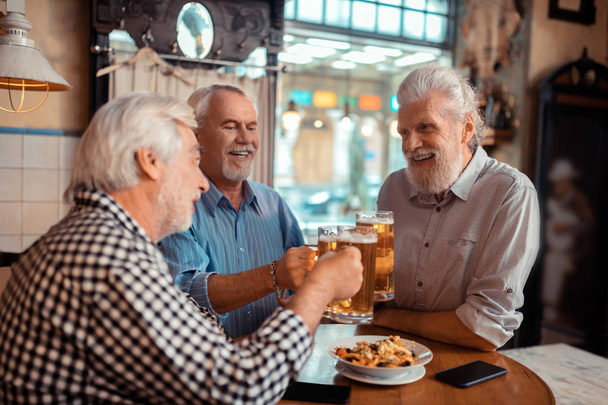 Positive pensioners clanging their glasses with beer - Foto, Imagem