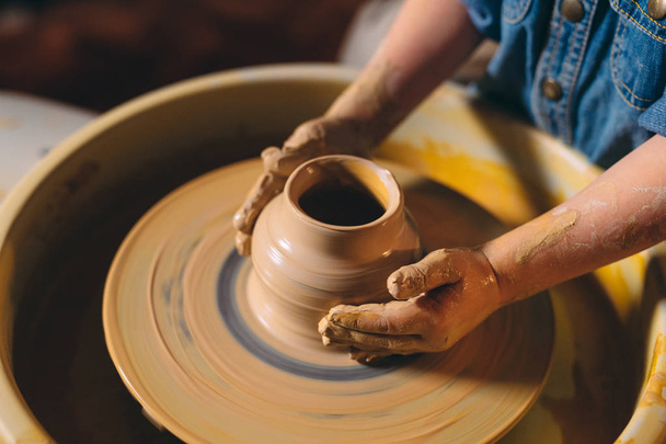 Pottery workshop. A little girl makes a vase of clay. Clay modeling - Fotografie, Obrázek
