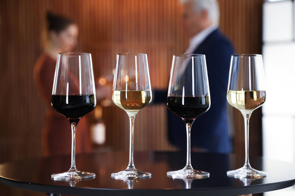 Glasses of different wines on table against blurred background - Foto, Imagem