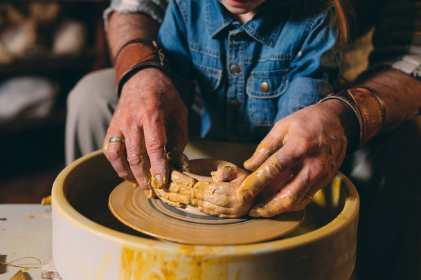 Pottery workshop. Grandpa teaches granddaughter pottery. Clay modeling - Photo, image