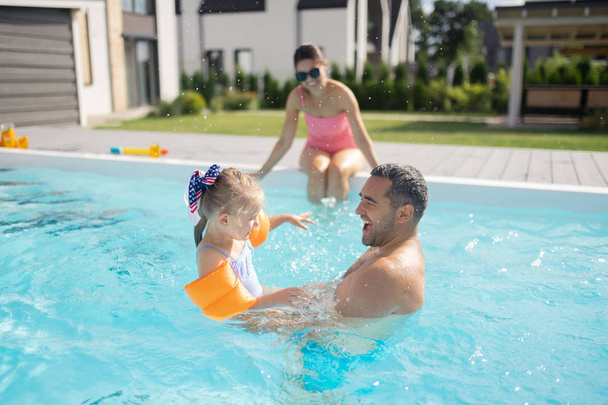 Pai sentindo-se feliz ao nadar com sua linda garota
 - Foto, Imagem