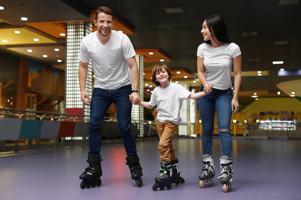 Happy family spending time at roller skating rink - Foto, afbeelding