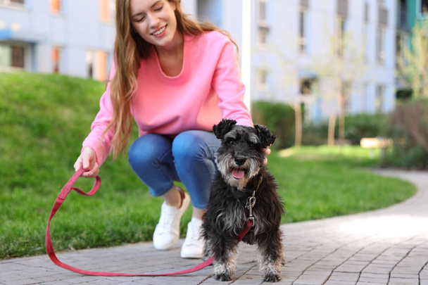 Young woman with Miniature Schnauzer dog outdoors - Foto, Imagem