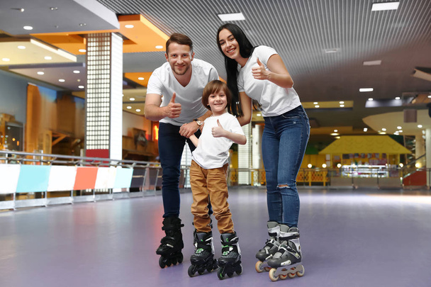 Happy family spending time at roller skating rink - Фото, изображение