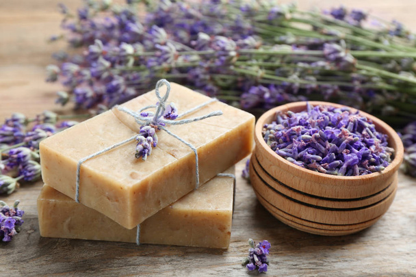Handmade soap bars with lavender flowers on brown wooden table, closeup - Foto, Imagem