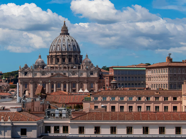 Beautiful aerial view on the St. Peter's Basilica ( Famous Roman landmark ) and ancient classical buildings of the Vatican on background of clouds. City of Rome. Italy. Europe - Photo, Image