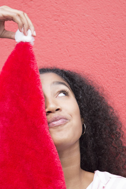 young afro woman playing with santa claus hat - Fotoğraf, Görsel