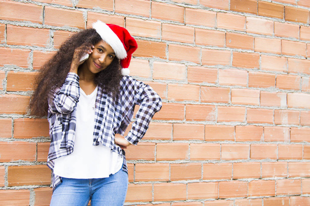 Κορίτσι με χριστουγεννιάτικο καπέλο να μιλάει στο τηλέφωνο. - Φωτογραφία, εικόνα