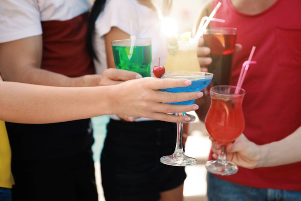 Друзья звонят в бокалы со свежими летними коктейлями на открытом воздухе, крупным планом
 - Фото, изображение