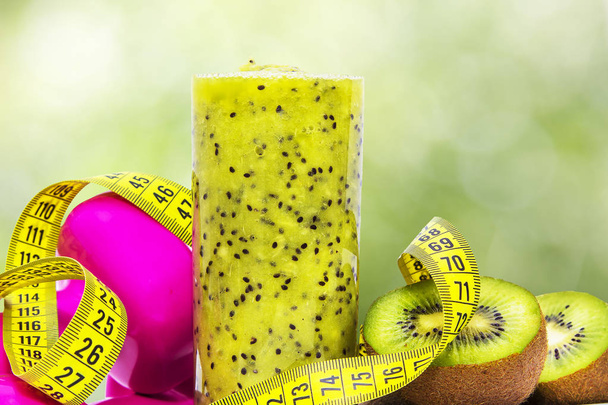 kiwis, tape measure, smoothie and dumbbells. diet and slimming concept - 写真・画像