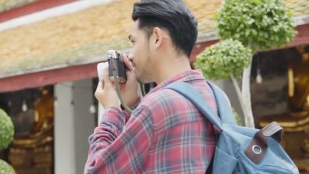 Vonzó fiatal ázsiai férfi turisták utazás és fotózás a templom Thaiföldön. Ázsiai férfi blogger boldog élvezi szabadidős életmód utazás. - Felvétel, videó