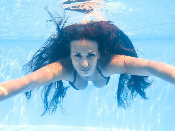 Young woman swimming underwater - Фото, изображение