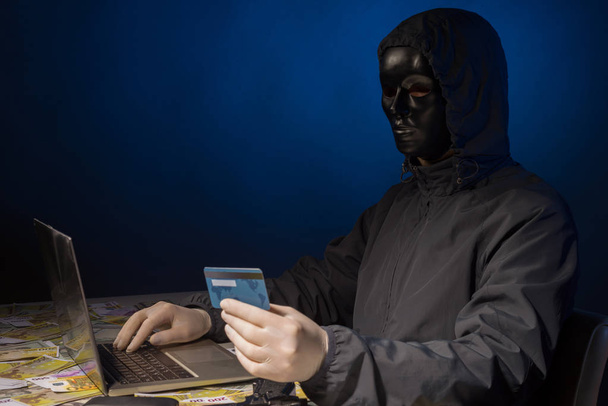 Hacker anônimo no programador máscara usa um laptop para hackear o sistema no escuro
. - Foto, Imagem