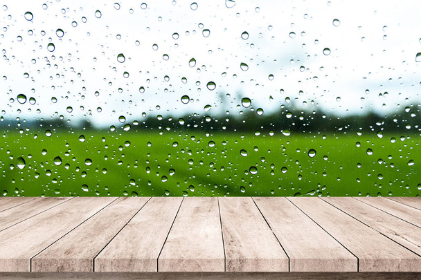 Holzboden mit Planken und Regenwetter auf Hintergrund mit Wassertropfen auf Glas  - Foto, Bild