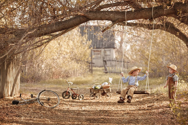 Children swinging on the swing in the yard - Photo, Image