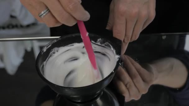 hair dye preparation, colorist stirs with a brush, beauty salon concept. 4K - Felvétel, videó