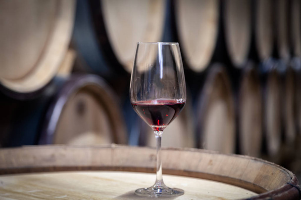 Closeup vidro com vinho tinto no fundo barril de carvalho de vinho de madeira
 - Foto, Imagem