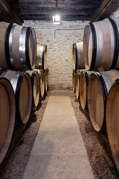 Barris de madeira do carvalho do vinho empilhados em fileiras retas na ordem, c velho
 - Foto, Imagem