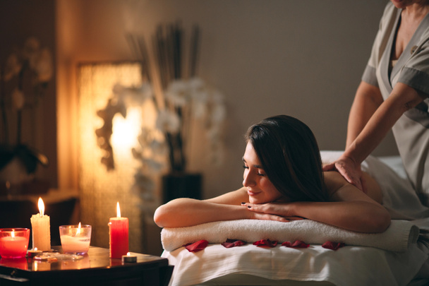 Wellness, Massage. Junge dunkelhaarige schöne Mädchen tun Massage. - Foto, Bild