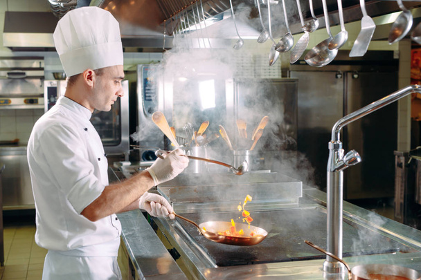 Chef cooking vegetables in wok pan. Shallow dof. - 写真・画像
