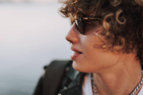 Curly man in sunglasses with piercing in nose - Фото, изображение