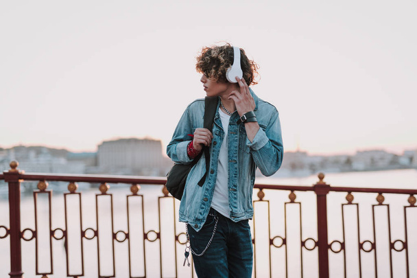 Serious man with headphones is walking outdoors - Photo, image