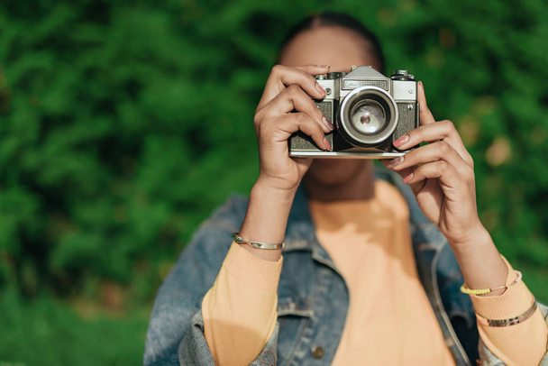 Young african american woman making photo at old camera - Foto, Bild
