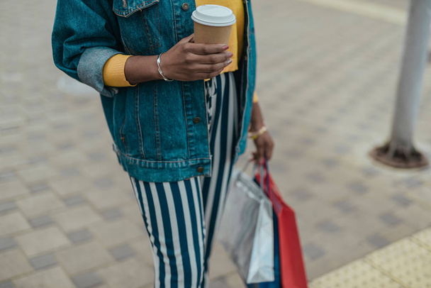 Young african american woman walking with shopping bag - Fotó, kép
